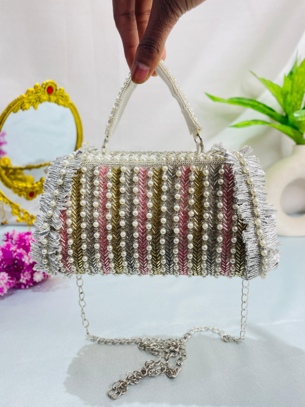 Reverse of the Noor clutch showing rows of pearl-style beads and striped embellishment