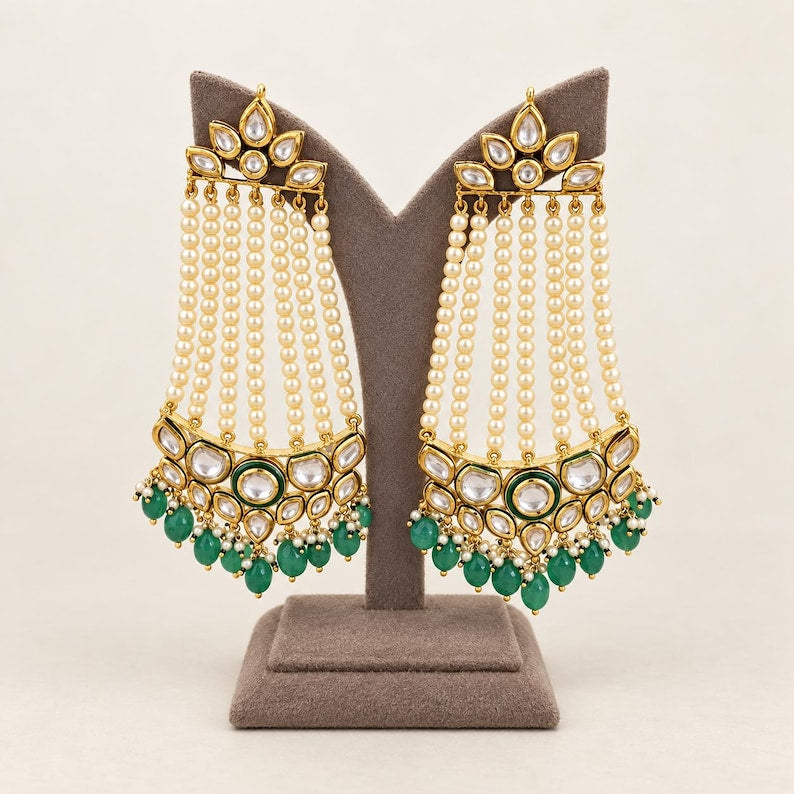 Front view of emerald and ivory pearl-strand kundan chandelier earrings